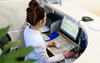 Female receptionist working the computer.
